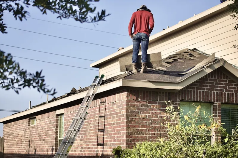 Professional roofer working on a residential roof in Essex Fells
